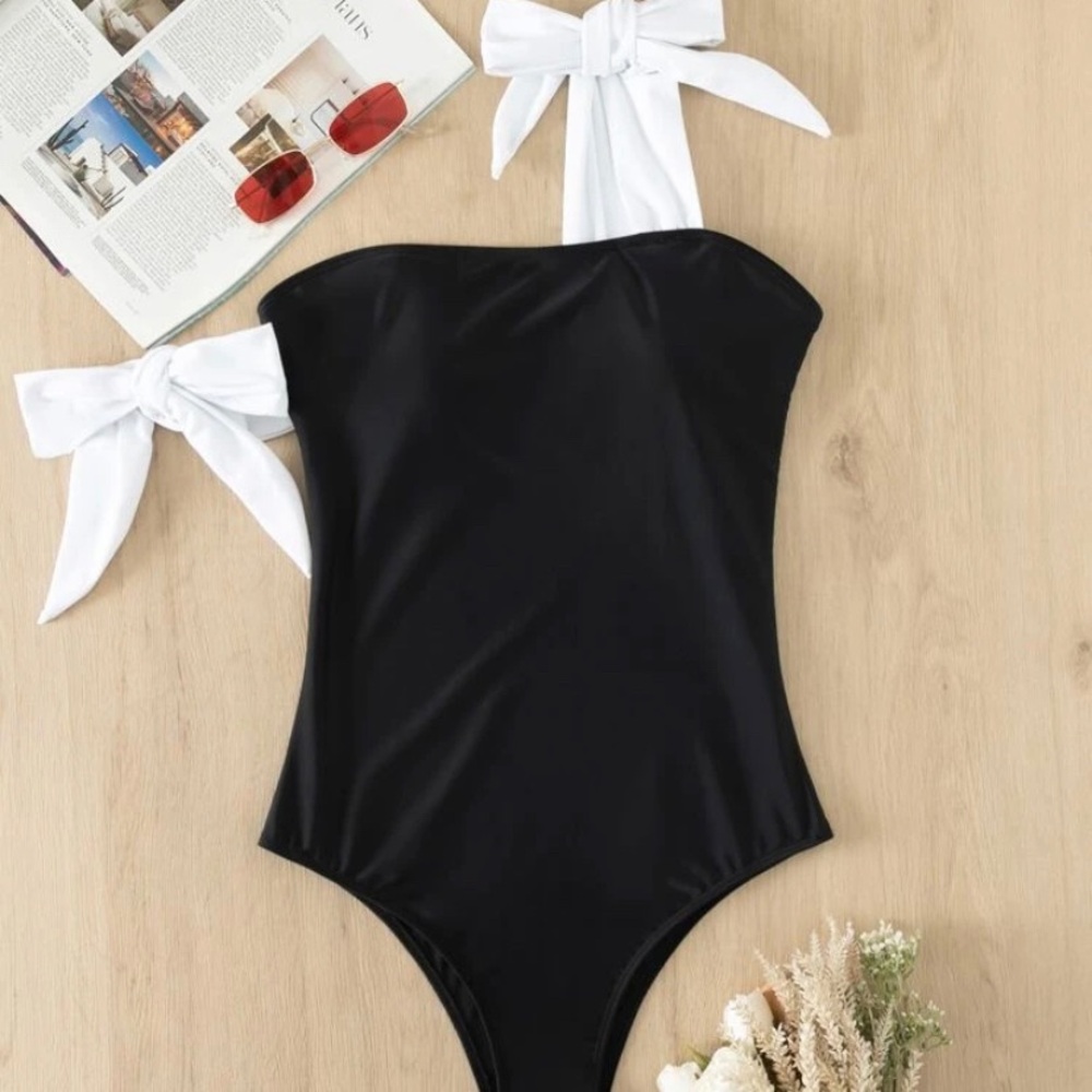 Woman’s black with white arm string bows bathing suit one crossed over on arm